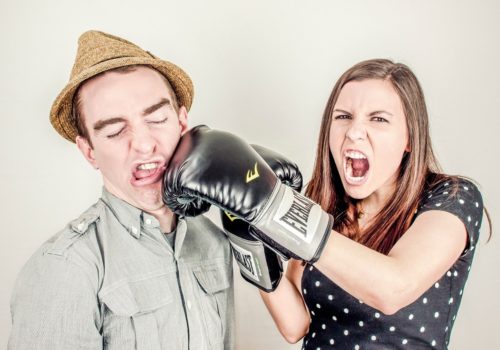 woman punching man in an argument introducing an article about the best books on conflict resolution
