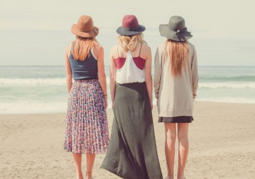 3 women standing together and looking at the ocean signifying relationships and the best books on polyamory